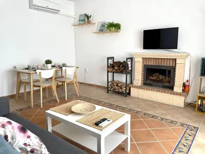 a living room with a fireplace and a tv at Chalet Wanderlust in Chiclana de la Frontera