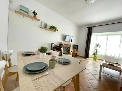 a dining room with a wooden table with plates on it at Chalet Wanderlust in Chiclana de la Frontera