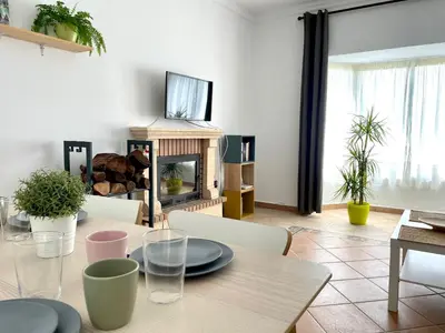 a living room with a table and a fireplace at Chalet Wanderlust in Chiclana de la Frontera