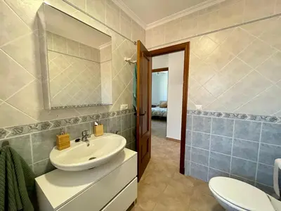 a bathroom with a sink and a toilet and a mirror at Chalet Wanderlust in Chiclana de la Frontera