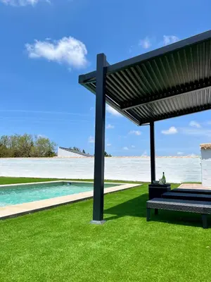 a bench under a pergola next to a swimming pool at Chalet Wanderlust in Chiclana de la Frontera