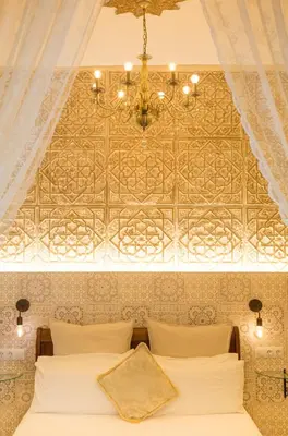 a bedroom with a bed with a ceiling with a chandelier at La Vista de Medina Studios & Apartments in Medina Sidonia