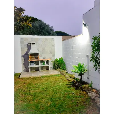 a small garden with a table in the yard at Villa Lola 14 in Chiclana de la Frontera