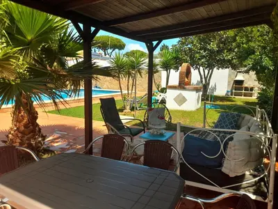 a patio with a table and chairs and a pool at Villa Lola 14 in Chiclana de la Frontera