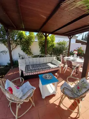a patio with a bench and chairs and a table at Villa Lola 14 in Chiclana de la Frontera