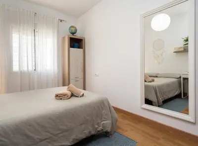 a bedroom with a bed and a large mirror at Apartoyou - Plaza San Juan in El Puerto de Santa María