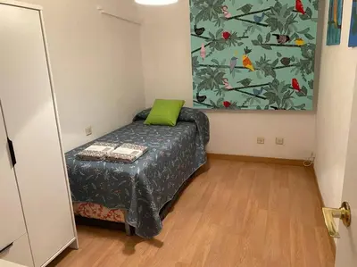 a bedroom with a bed with a green pillow on it at Excelente piso en San Fernando in San Fernando