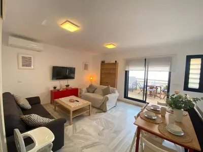 a living room with a couch and a table at Dúplex en casco histórico, terraza, garaje, Wi-Fi in Sanlúcar de Barrameda