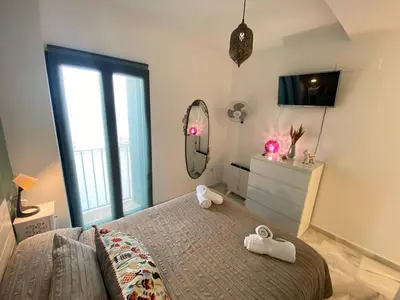 a bedroom with a bed and a mirror and a dresser at Dúplex en casco histórico, terraza, garaje, Wi-Fi in Sanlúcar de Barrameda