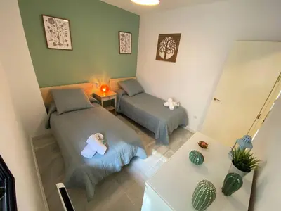 a small room with two beds and a table at Dúplex en casco histórico, terraza, garaje, Wi-Fi in Sanlúcar de Barrameda
