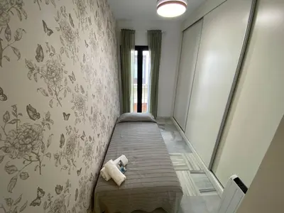 a small room with a bed and a wall at Dúplex en casco histórico, terraza, garaje, Wi-Fi in Sanlúcar de Barrameda