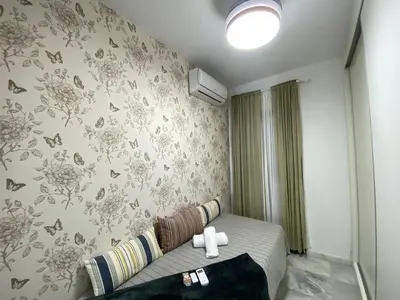 a bedroom with a bed and a wall with butterflies at Dúplex en casco histórico, terraza, garaje, Wi-Fi in Sanlúcar de Barrameda