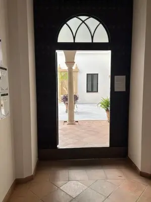 an entrance to a building with an open door at Dúplex en casco histórico, terraza, garaje, Wi-Fi in Sanlúcar de Barrameda