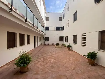 an empty courtyard of a building with potted plants at Dúplex en casco histórico, terraza, garaje, Wi-Fi in Sanlúcar de Barrameda
