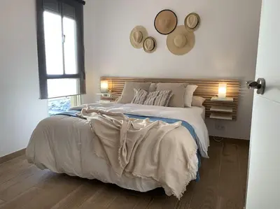 a bedroom with a large bed and a window at Azvalia - Valdelagrana Mirador de la Bahía, Playa, piscina, parking, vistas ! in El Puerto de Santa María