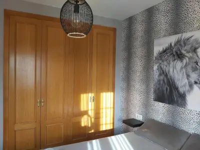 a bedroom with a bed and a picture of a horse on the wall at VILLA DEL MAR in Novo Sancti Petri