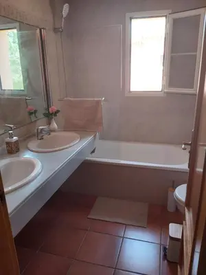 a bathroom with two sinks and a tub and a window at VILLA DEL MAR in Novo Sancti Petri