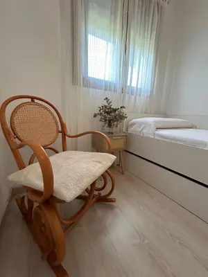 a room with a rocking chair and a bed at BAJO GUÍA DELUXE in Sanlúcar de Barrameda