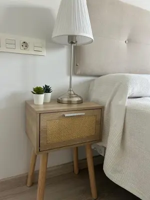 a bed with a table with a lamp on it at BAJO GUÍA DELUXE in Sanlúcar de Barrameda