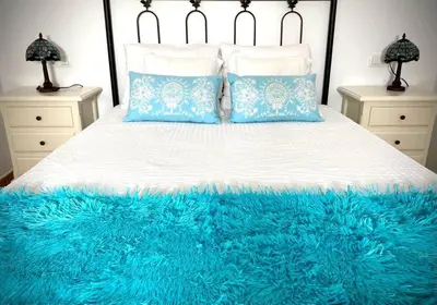 a large bed with a blue blanket on it at MyChoice Dadim in Rota