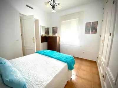 a bedroom with a bed with a blue blanket on it at MyChoice Dadim in Rota