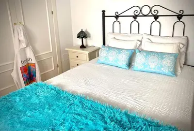 a bedroom with a bed with a blue blanket on it at MyChoice Dadim in Rota