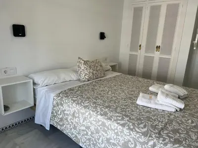 a bedroom with a bed with towels on it at Apartamento Columela in Chiclana de la Frontera