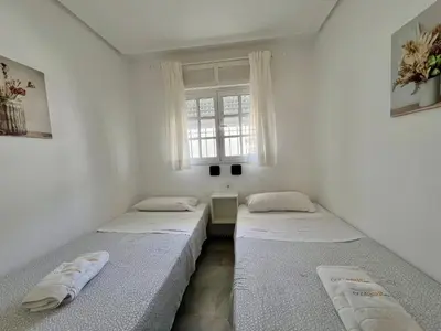 two beds in a room with a window at Apartamento Columela in Chiclana de la Frontera