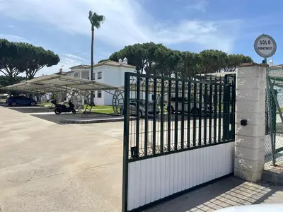 a gate in front of a parking lot with a playground at Apartamento Columela in Chiclana de la Frontera