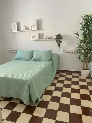 a bedroom with a bed and a checkered floor at Apartamentos Arquillo de Rota in Sanlúcar de Barrameda