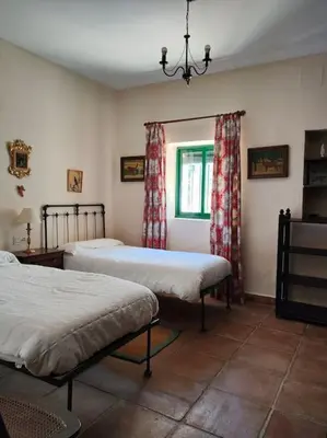 a bedroom with two beds and a window at Casa de campo - Cortijo El Palomar in Alcántara