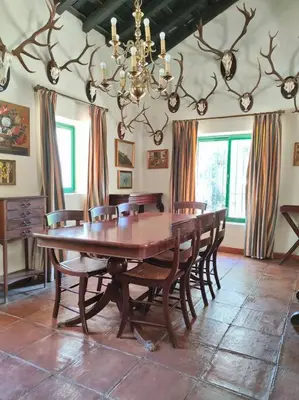 a dining room with a large wooden table and chairs at Casa de campo - Cortijo El Palomar in Alcántara