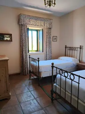 a bedroom with two beds and a window at Casa de campo - Cortijo El Palomar in Alcántara