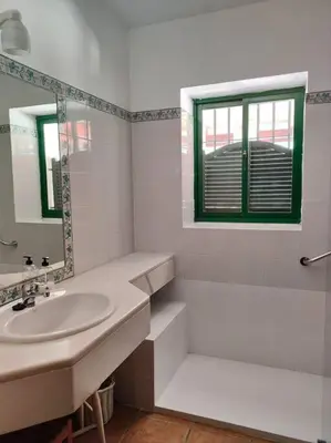 a white bathroom with a sink and a mirror at Casa de campo - Cortijo El Palomar in Alcántara