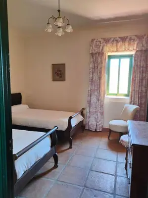 a bedroom with two beds and a window at Casa de campo - Cortijo El Palomar in Alcántara