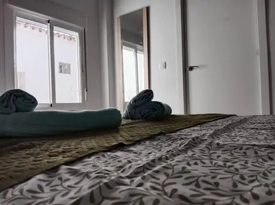 a bedroom with a bed with two pillows on it at Apartamento Peonía in Jerez de la Frontera
