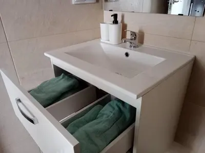 a bathroom with a white sink and green towels at Apartamento Peonía in Jerez de la Frontera