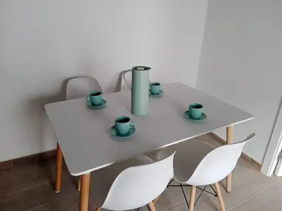 a white table with cups on it with chairs at Apartamento Peonía in Jerez de la Frontera