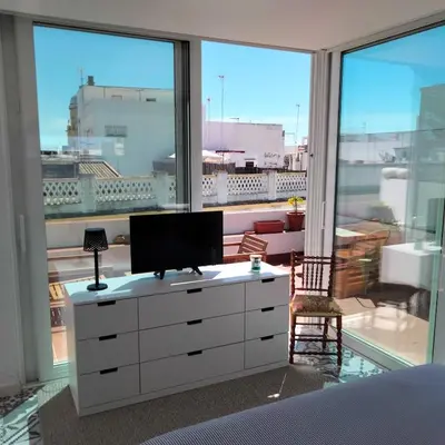 a bedroom with a white dresser with a tv on it at Rosario17 by 7Escalones in Rota