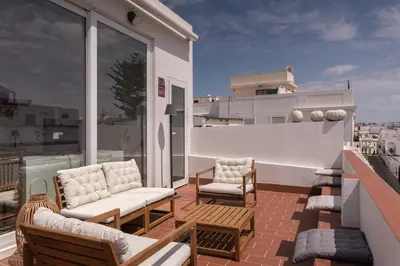 a balcony with chairs and tables on a roof at Rosario17 by 7Escalones in Rota