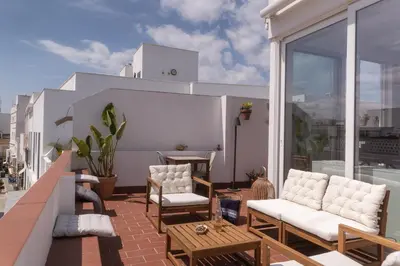 a balcony with chairs and a table on a building at Rosario17 by 7Escalones in Rota