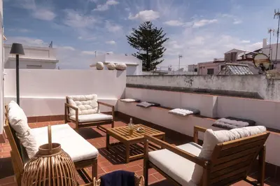 a balcony with chairs and tables on a roof at Rosario17 by 7Escalones in Rota