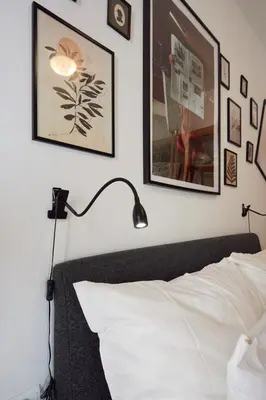 a bedroom with a bed with a lamp and pictures on the wall at Apartamento Obispo centro Jerez de la Frontera in Jerez de la Frontera