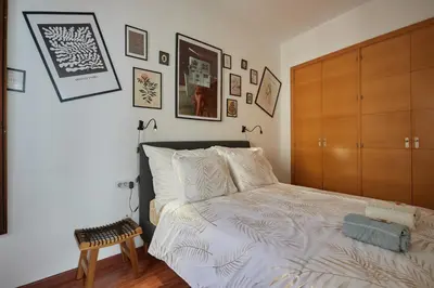 a bedroom with a bed and a wooden cabinet at Apartamento Obispo centro Jerez de la Frontera in Jerez de la Frontera