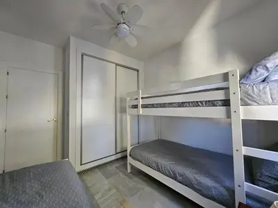 a bedroom with two bunk beds and a ceiling fan at Victoria Costa Sancti Petri in Novo Sancti Petri