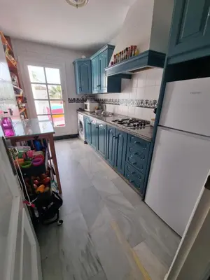 a kitchen with blue cabinets and a white refrigerator at Victoria Costa Sancti Petri in Novo Sancti Petri