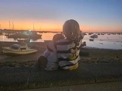 a woman sitting on the ground looking at the water at Victoria Costa Sancti Petri in Novo Sancti Petri