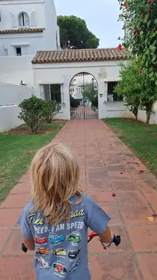 a young child riding a bike down a sidewalk at Victoria Costa Sancti Petri in Novo Sancti Petri