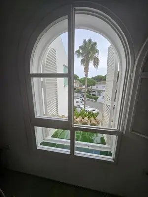 an arched window with a view of a palm tree at Victoria Costa Sancti Petri in Novo Sancti Petri