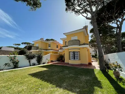 a large yellow house with a yard at Chalet Violeta in Chiclana de la Frontera